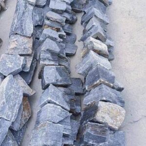 A close-up view of a textured stacked stone panel in natural colors