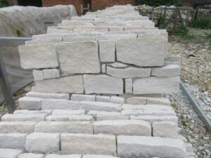 Factory staff inspecting and arranging granite Z-panel stone slabs for consistent color and quality in bulk orders