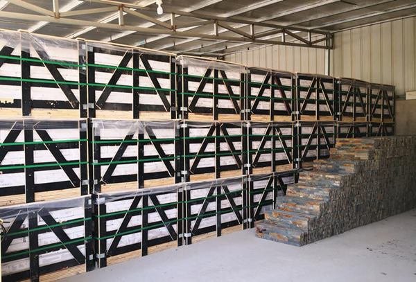 Stacked stone panels packed in cartons and strapped to export pallets